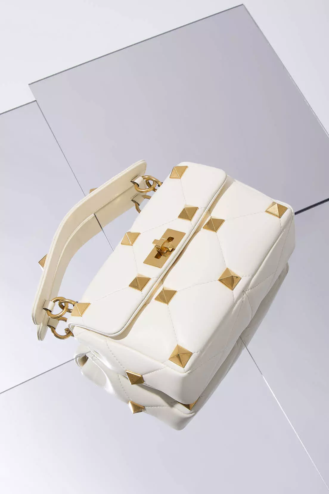 Shop by Brand: Valentino White leather Rockstud crossbody bag on a mirrored surface
